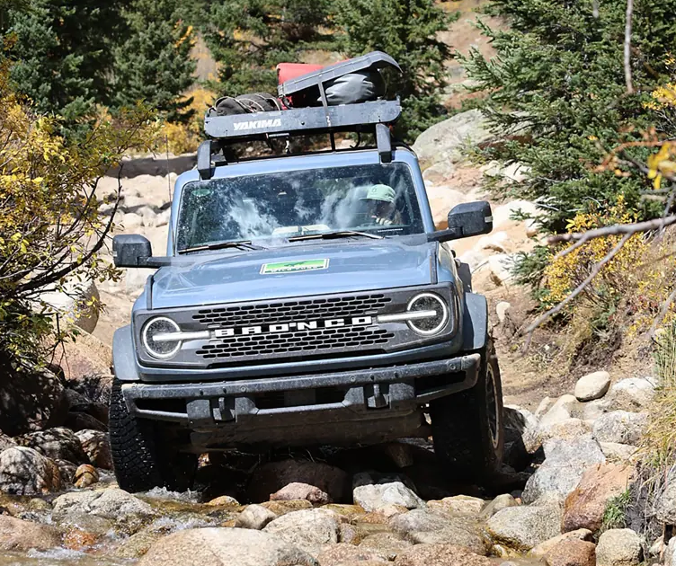 Custom Ford Bronco driving on the rocks