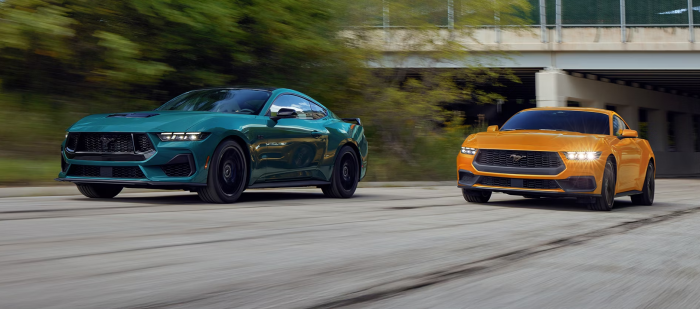 Two 2026 Ford Mustangs driving down road